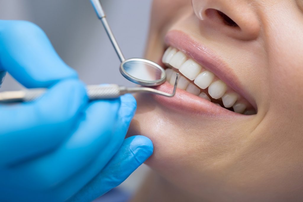 girl with beautiful white teeth on reception at the doctor dentist.